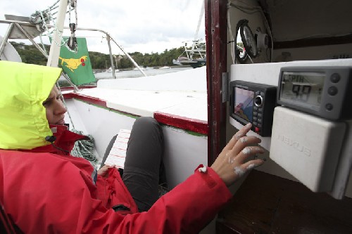 Jess pretending she knows what the buttons on the Chartplotter do. Neither of us have had time to read any manuals yet. Nice swing out panel though yes?