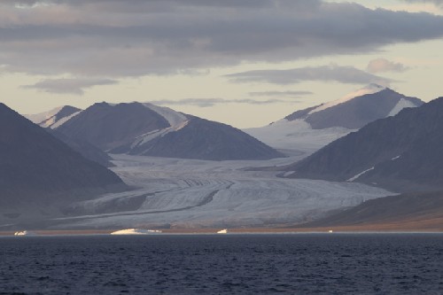 Glacier spilling out from between the mountains