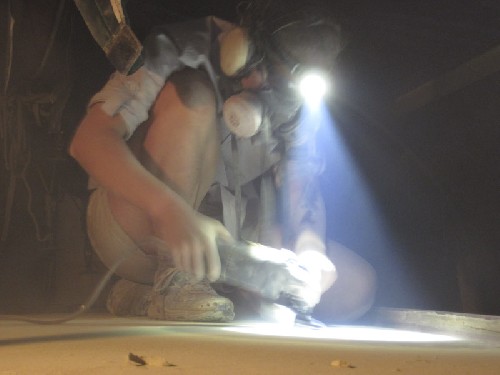 Jess grinding the paint off the deck at night ready to fibre glass